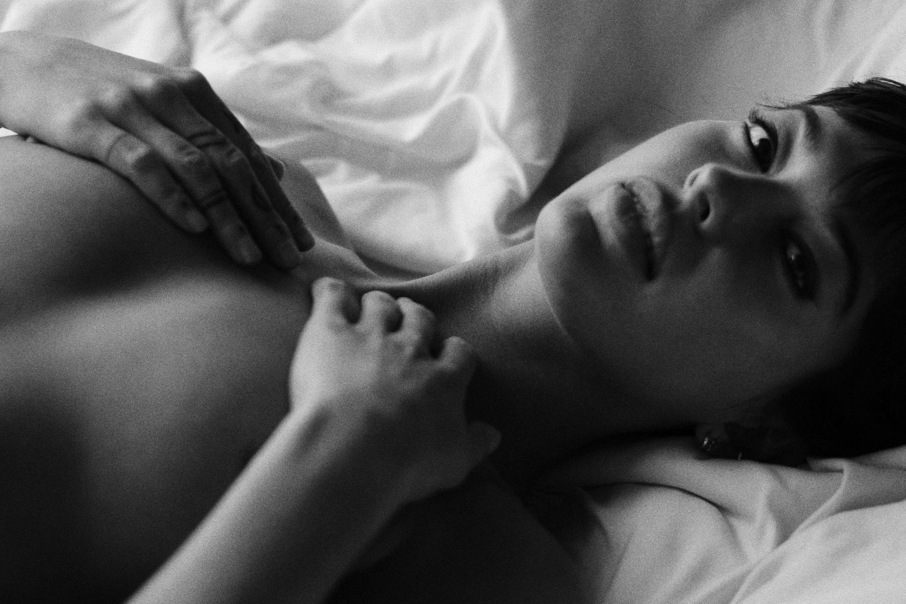 Woman lying on white sheets, intimate black and white fine art photograph by ARMAND